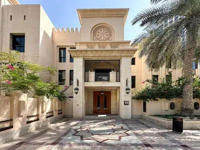 an entrance to a building with a palm tree at Arabian Nights Luxury Garden Suite in Dubai