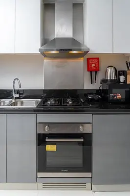a kitchen with a stove and a sink at DAMAC MAISON PRIVE SLEEP FOUr in Dubai