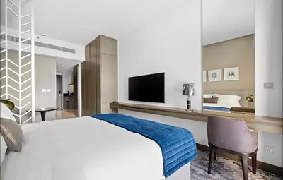 a bedroom with a large bed and a television at DAMAC MAISON PRIVE SLEEP FOUr in Dubai