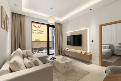 a living room with a white couch and a tv at Brand New 2BR, Circle Mall View, Great Pool & Gym in Dubai