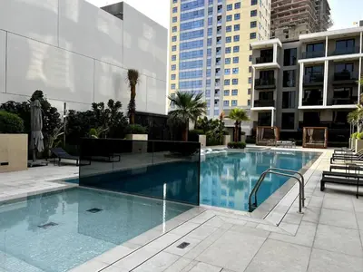 a large swimming pool in a city with buildings at Brand New 2BR, Circle Mall View, Great Pool & Gym in Dubai
