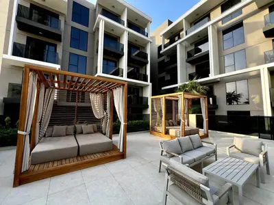 a patio with a gazebo and chairs in front of a building at Brand New 2BR, Circle Mall View, Great Pool & Gym in Dubai
