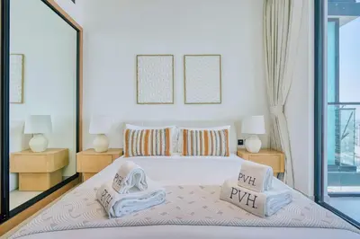a bedroom with a large bed with two night stands at PVH - Binghatti Lavender - Tranquil Modern 1BR - Near JVC Community Park in Dubai