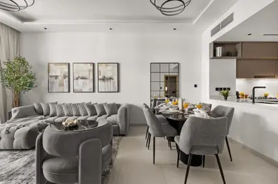 a living room with a couch and a table and chairs at Stylish 2 Bedrooms, Pool, Gym & Family-Friendly in Dubai