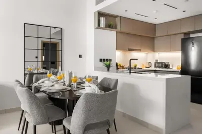 a dining room with a table and chairs in a kitchen at Stylish 2 Bedrooms, Pool, Gym & Family-Friendly in Dubai