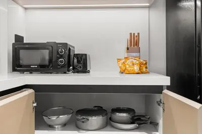 a microwave and a television on a shelf in a kitchen at Stylish 2 Bedrooms, Pool, Gym & Family-Friendly in Dubai