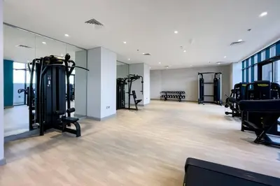 a gym with several treadmills and machines in a room at Stylish Studio in Nad Al Sheba in Dubai