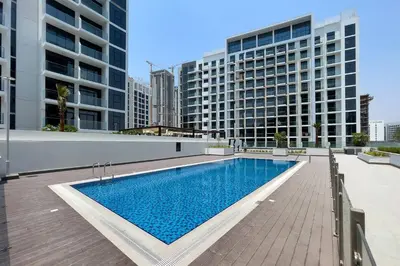 a swimming pool in the middle of a building with tall buildings at Stylish Studio in Nad Al Sheba in Dubai