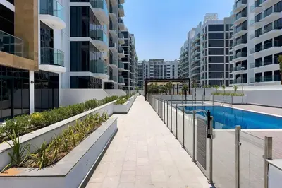 a walkway in the middle of a building with a pool at Stylish Studio in Nad Al Sheba in Dubai