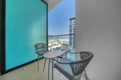 a room with two chairs and a table on a balcony at Brand New Luxury Studio, Amazing Pool & Gym in Dubai