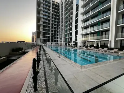 a large building with a swimming pool next to a building at Brand New Luxury Studio, Amazing Pool & Gym in Dubai