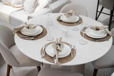a white dining room table with plates and napkins at Chic 1BR Getaway, Sleeps 4, Stunning Pool Views in Dubai