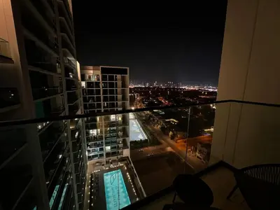 a view of a city at night from a building at Chic 1BR Getaway, Sleeps 4, Stunning Pool Views in Dubai