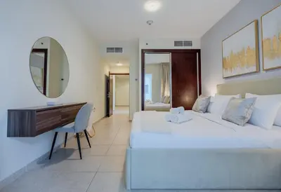 a bedroom with a large white bed and a desk at TRPS - Elite Residence, Dubai Marina - Modern High-Rise, Near Popular Sites, Partial Sea View in Dubai