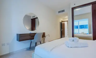 a bedroom with a bed and a desk and a mirror at TRPS - Elite Residence, Dubai Marina - Modern High-Rise, Near Popular Sites, Partial Sea View in Dubai