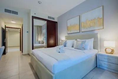 a bedroom with a large white bed with a blue light at TRPS - Elite Residence, Dubai Marina - Modern High-Rise, Near Popular Sites, Partial Sea View in Dubai