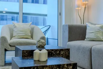 a living room with two couches and a table at TRPS - Elite Residence, Dubai Marina - Modern High-Rise, Near Popular Sites, Partial Sea View in Dubai