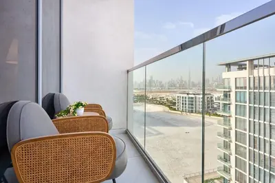 a balcony with chairs and a view of a city at Newly Furnished Apt in District 1 in Dubai