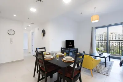 a dining room and living room with a table and chairs at 2BR in Safi Balcony Walk to Town Sq Park in Dubai