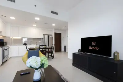 a living room with a tv and a kitchen at 2BR in Safi Balcony Walk to Town Sq Park in Dubai
