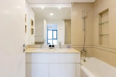 a bathroom with two sinks and a tub and a mirror at 2BR in Safi Balcony Walk to Town Sq Park in Dubai