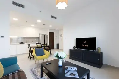 a living room with a couch and a tv and a table at 2BR in Safi Balcony Walk to Town Sq Park in Dubai