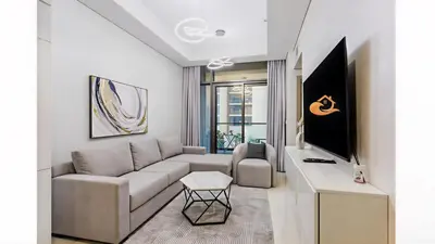 a living room with a couch and a tv at Modern Luxury Stylish 2BR Near Downtown in Dubai