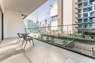 a balcony with a table and a view of the city at Spacious Balcony Overlooking the Burj Khalifa and City Skyline, Near Bus Station, Quick Drive from Downtown Top Attractions, Binghatti Canal, Business Bay by Deluxe Holiday Homes in Dubai