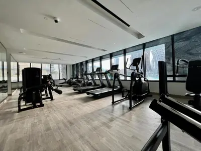 a gym with a bunch of treadmills and ellipticals at Spacious Balcony Overlooking the Burj Khalifa and City Skyline, Near Bus Station, Quick Drive from Downtown Top Attractions, Binghatti Canal, Business Bay by Deluxe Holiday Homes in Dubai