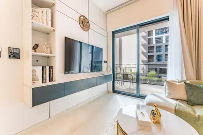 a living room with a tv and a large window at Spacious Balcony Overlooking the Burj Khalifa and City Skyline, Near Bus Station, Quick Drive from Downtown Top Attractions, Binghatti Canal, Business Bay by Deluxe Holiday Homes in Dubai