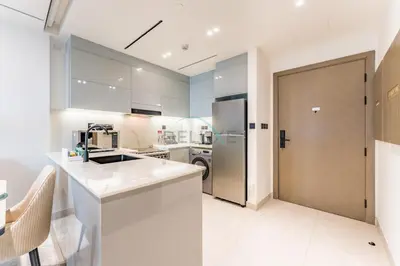a kitchen with a sink and a refrigerator at Spacious Balcony Overlooking the Burj Khalifa and City Skyline, Near Bus Station, Quick Drive from Downtown Top Attractions, Binghatti Canal, Business Bay by Deluxe Holiday Homes in Dubai