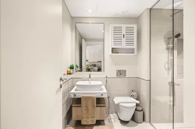 a bathroom with a toilet and a sink and a shower at Modern and family friendly 1 bed in Dubai