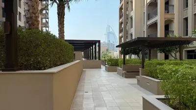 a walkway in a city with buildings and plants at Modern and family friendly 1 bed in Dubai