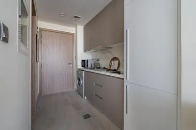 a kitchen with a refrigerator and a washer at GuestReady - Sunny Retreat near Dubai Frame in Dubai