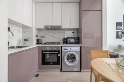 a kitchen with a washing machine and a sink at GuestReady - Contemporary elegance in Dubai in Dubai