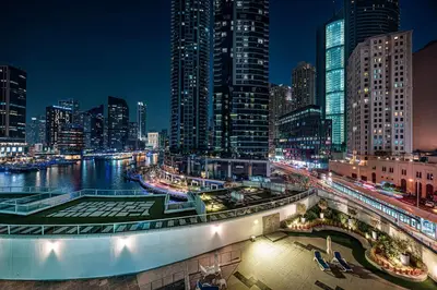 a city skyline at night with a river and buildings at Marina Waterfront Bliss - Steps from Promenade in Dubai