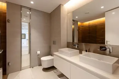 a bathroom with two sinks and a toilet and a mirror at Bluewaters 2B Iconic Ain Dubai and Sea View in Dubai