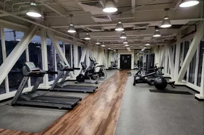 a gym with a row of treadmills and exercise bikes at New Large 2BR Apt Sleeps 10 Adults with Pool Gym Parking and Wifi in Dubai