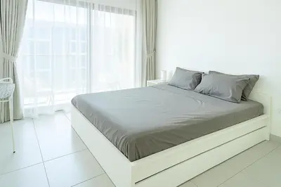 a white bed in a white room with a window at New Large 2BR Apt Sleeps 10 Adults with Pool Gym Parking and Wifi in Dubai