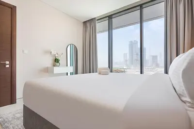 a white bedroom with a large bed and a large window at STAY BY LATINEM Luxury 1BR Holiday Home CVG 604 Near Downtown in Dubai