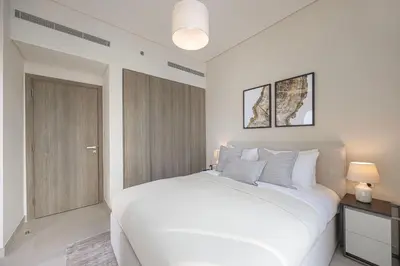 a white bedroom with a large white bed and a door at Daniels 2BR at Liv Marina with Marina View in Dubai