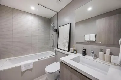 a bathroom with a sink and a toilet and a tub at Daniels 2BR at Liv Marina with Marina View in Dubai