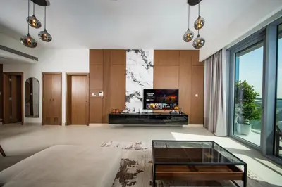 a living room with a tv and a glass table at Luxury 1 Bedroom Canalfront Apartment with Burj Khalifa Views from Resort-Style Pool - Walk to Jumeirah Beach in Dubai