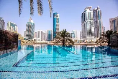 a large swimming pool in a city with tall buildings at Marina Oasis JBR Beach in Dubai