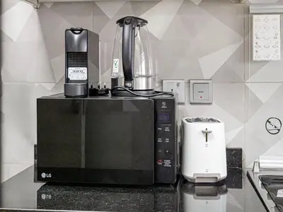 a kitchen counter with a coffee maker and a microwave at Livin' Holidays - 2BR - Skyline View with Burj Glimpse in Dubai