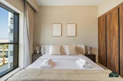 a bedroom with a bed with two towels on it at Chic 1BR, Next to Metro by BMS in Dubai
