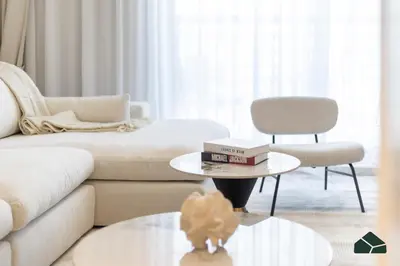 a living room with a couch and a table with books on it at Chic 1BR, Next to Metro by BMS in Dubai