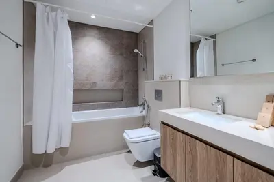 a bathroom with a toilet and a sink and a tub at TRPS - Downtown Views II T2, Downtown Dubai - Modern 3BR Home, Maids Room, Full Burj Khalifa View in Dubai