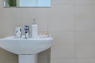 a white sink in a bathroom with a mirror at TRPS - Downtown Views II T2, Downtown Dubai - Modern 3BR Home, Maids Room, Full Burj Khalifa View in Dubai
