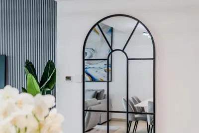 an archway mirror in a living room with a couch at TRPS - Downtown Views II T2, Downtown Dubai - Modern 3BR Home, Maids Room, Full Burj Khalifa View in Dubai